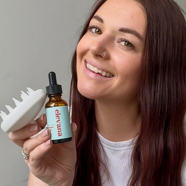 Woman holding a bottle of 'elevana' product and a white brush against a gray background