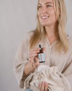 Woman holding a dropper bottle with a beige background