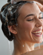 Woman washing her hair with shampoo in a shower setting