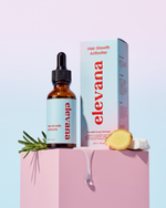 A bottle of elevana Hair Growth Activator next to its product box, styled on a pink pedestal with rosemary and ginger slices against a pastel gradient background.